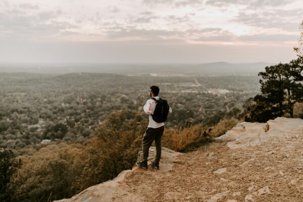 introspective man overlooking community from cliftop